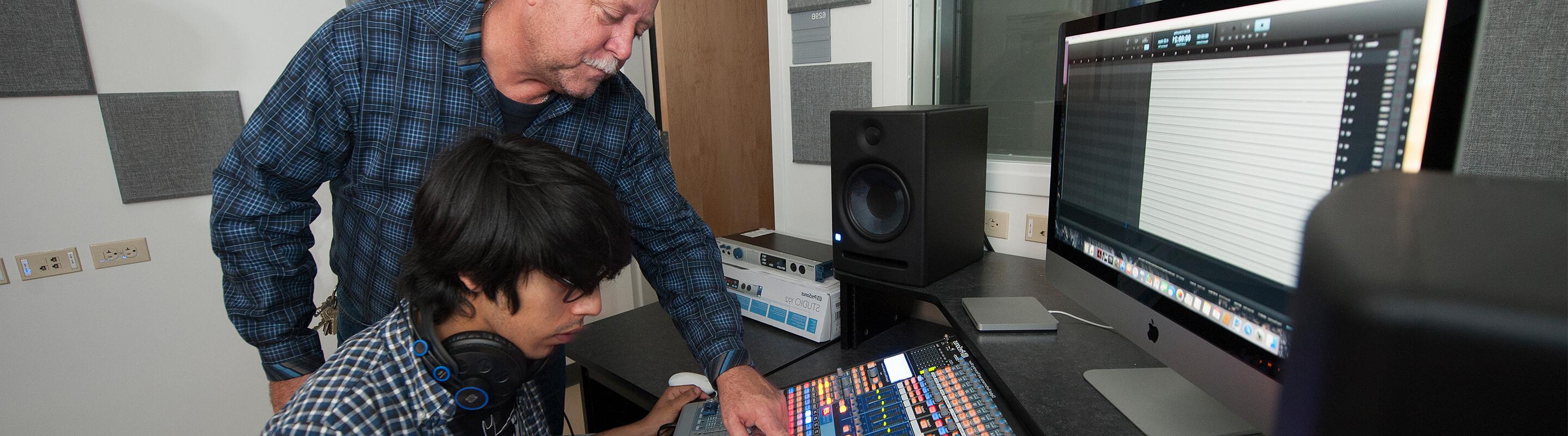 Professor guiding student on equipment use